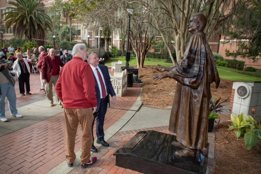 President Richard McCullough and President Emeritus John Thrasher share a moment in front of Thrasher's statue following the dedication ceremony Saturday, Nov. 19, 2022, at Westcott Plaza. (FSU Photography Services)