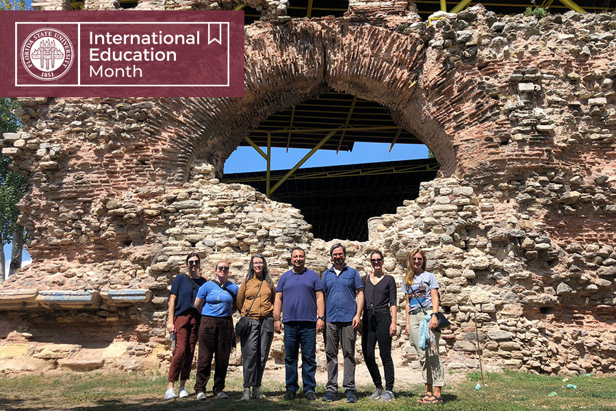 Jones, in mustard shirt, poses with students and colleagues at an archaeological site in Türkiye. (L to R) Maddie Gilmore-Duffey, Sarah Mathiesen, Lynn Jones, host, Brad Hostetler, Caitlin, Emma Huston)