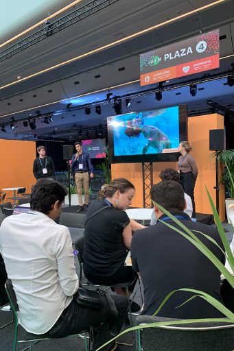 Gabriel Bonassi, the student leader of FSU’s iGEM team, presents during the Paris competition. With him are Elizabeth Moore, right, and Andrew Taylor, left.