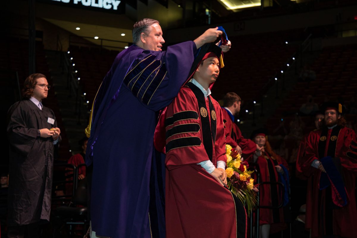 A Florida State University faculty hoods a doctoral graduate the summer doctoral hooding ceremony Friday, Aug. 4, 2023, at the Donald L. Tucker Civic Center. (FSU Photography)