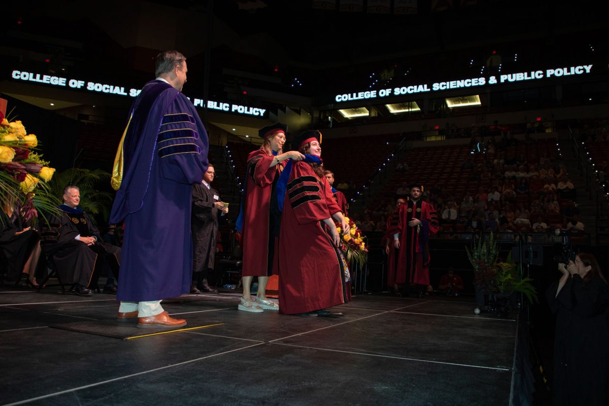 A Florida State University faculty hoods a doctoral graduate the summer doctoral hooding ceremony Friday, Aug. 4, 2023, at the Donald L. Tucker Civic Center. (FSU Photography)