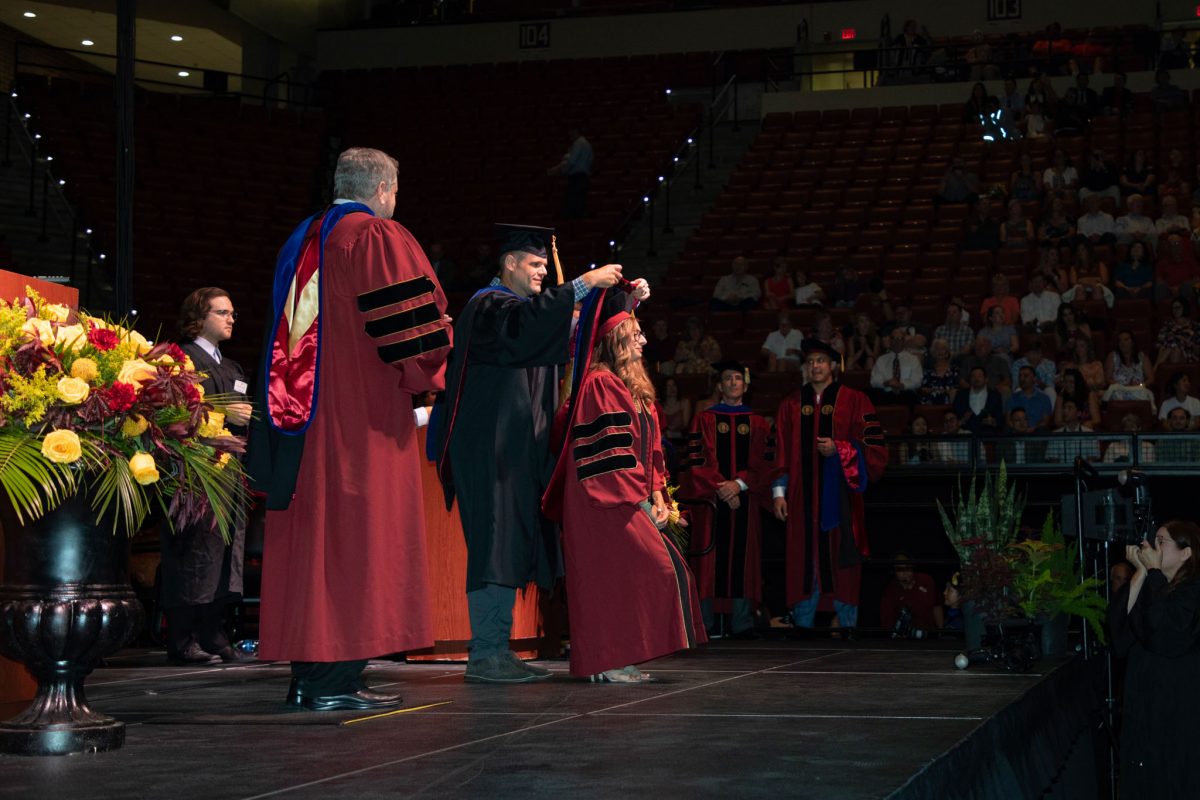 A Florida State University faculty hoods a doctoral graduate the summer doctoral hooding ceremony Friday, Aug. 4, 2023, at the Donald L. Tucker Civic Center. (FSU Photography)