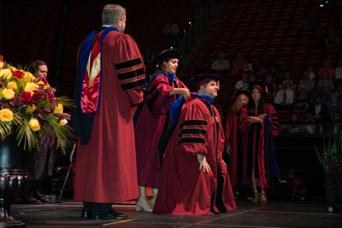 A Florida State University faculty hoods a doctoral graduate the summer doctoral hooding ceremony Friday, Aug. 4, 2023, at the Donald L. Tucker Civic Center. (FSU Photography)