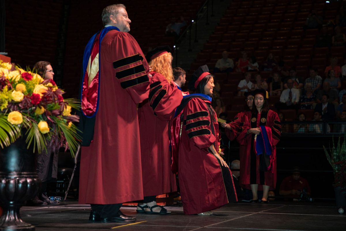 A Florida State University faculty hoods a doctoral graduate the summer doctoral hooding ceremony Friday, Aug. 4, 2023, at the Donald L. Tucker Civic Center. (FSU Photography)