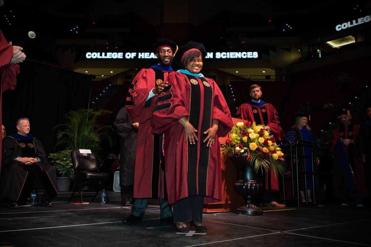 A Florida State University faculty hoods a doctoral graduate the summer doctoral hooding ceremony Friday, Aug. 4, 2023, at the Donald L. Tucker Civic Center. (FSU Photography)