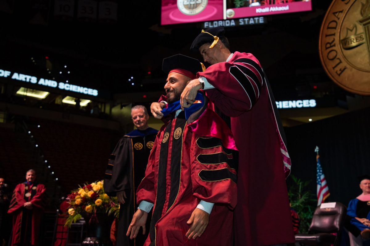 A Florida State University faculty hoods a doctoral graduate the summer doctoral hooding ceremony Friday, Aug. 4, 2023, at the Donald L. Tucker Civic Center. (FSU Photography)