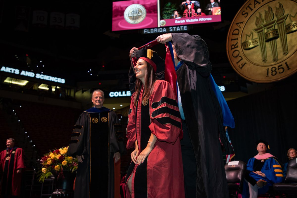 A Florida State University faculty hoods a doctoral graduate the summer doctoral hooding ceremony Friday, Aug. 4, 2023, at the Donald L. Tucker Civic Center. (FSU Photography)