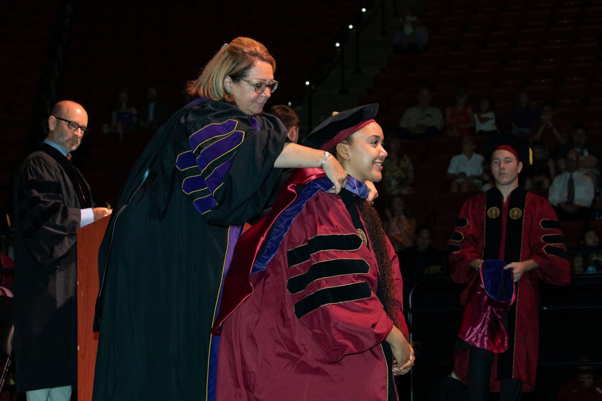 A Florida State University faculty hoods a doctoral graduate the summer doctoral hooding ceremony Friday, Aug. 4, 2023, at the Donald L. Tucker Civic Center. (FSU Photography)