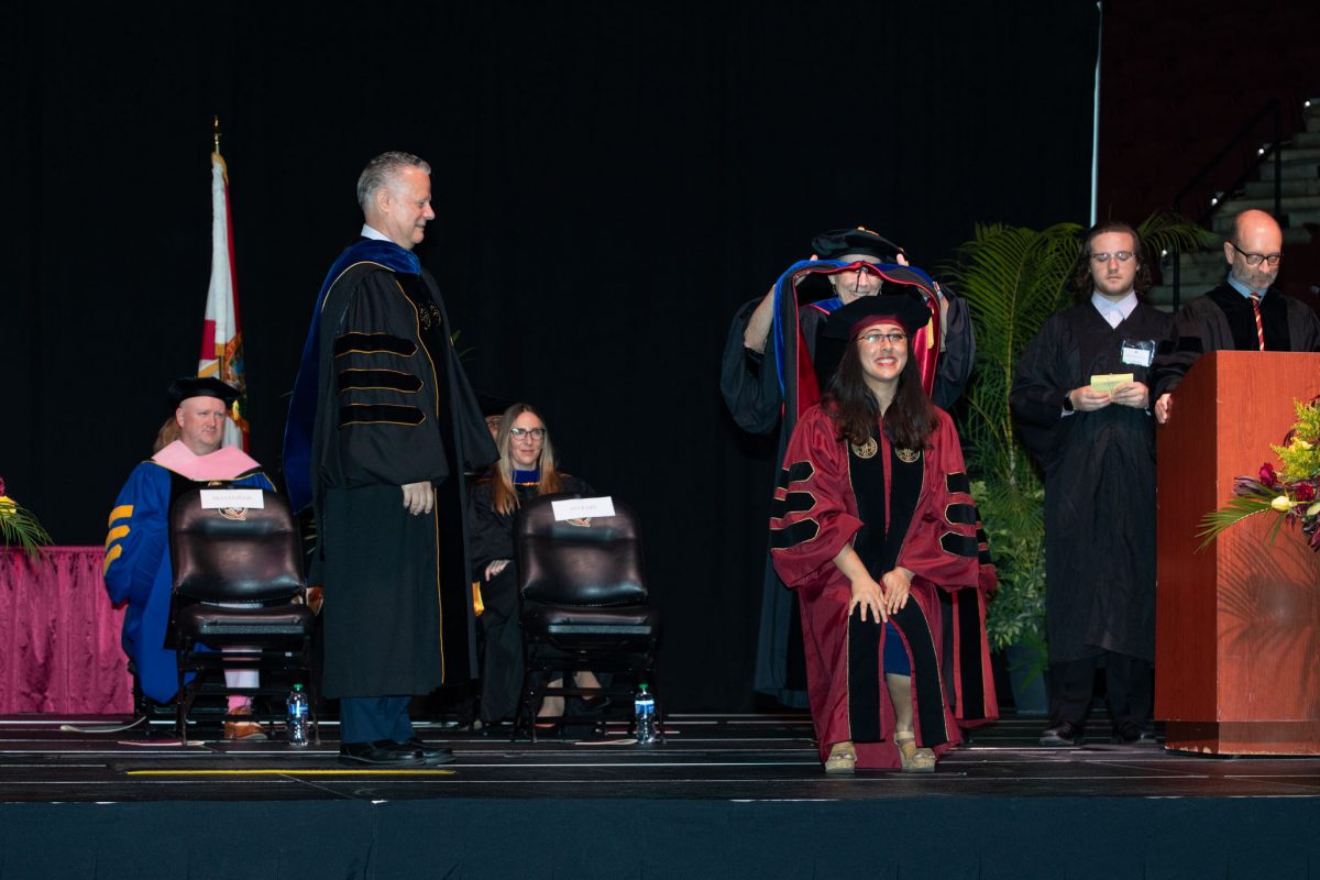 A Florida State University faculty hoods a doctoral graduate the summer doctoral hooding ceremony Friday, Aug. 4, 2023, at the Donald L. Tucker Civic Center. (FSU Photography)