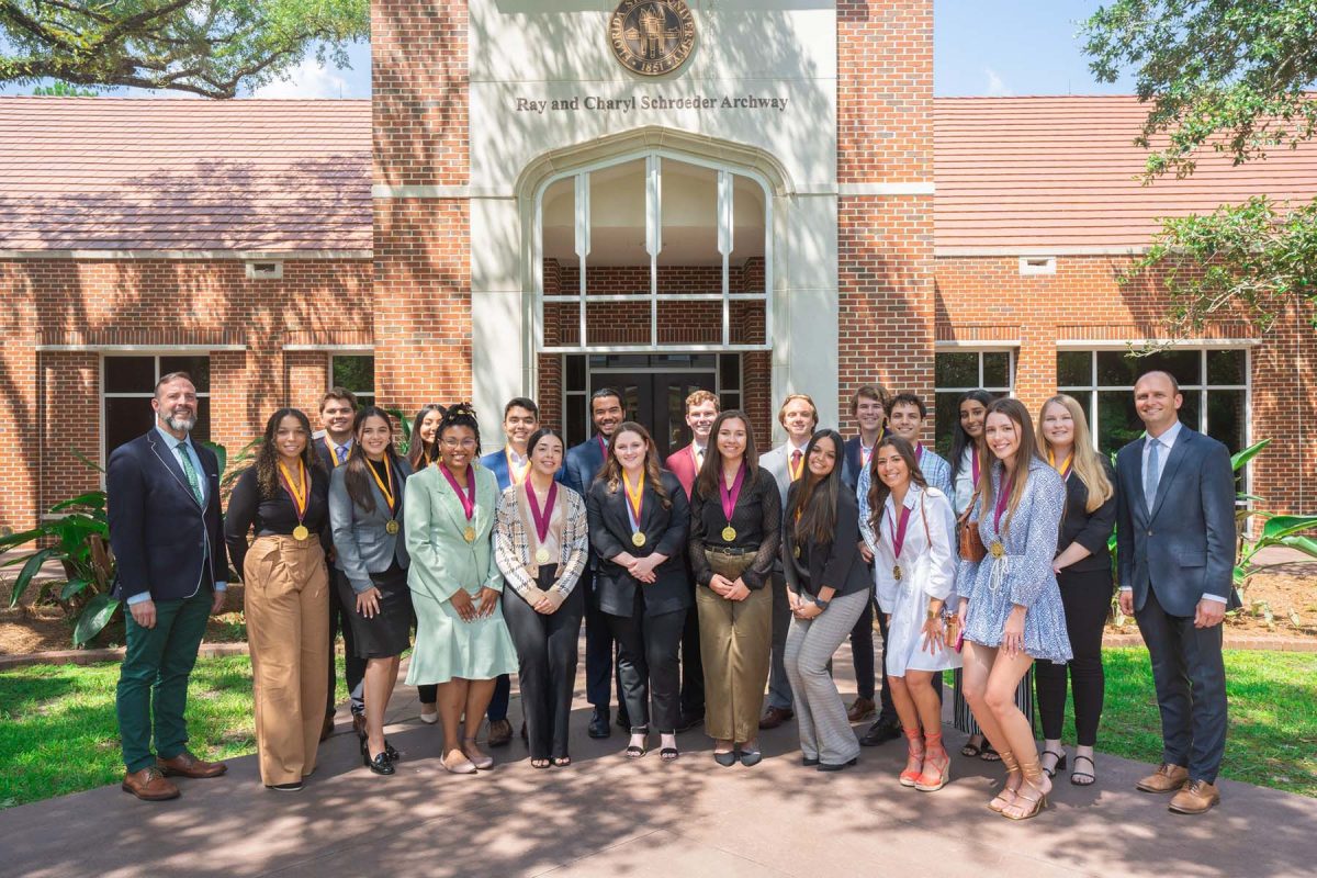 Graduates pose with their honors medallions alongside Craig Filar (left), associate dean of undergraduate studies and interim director of the Honors Program, and Joe O'Shea (right), dean of undergraduate studies.