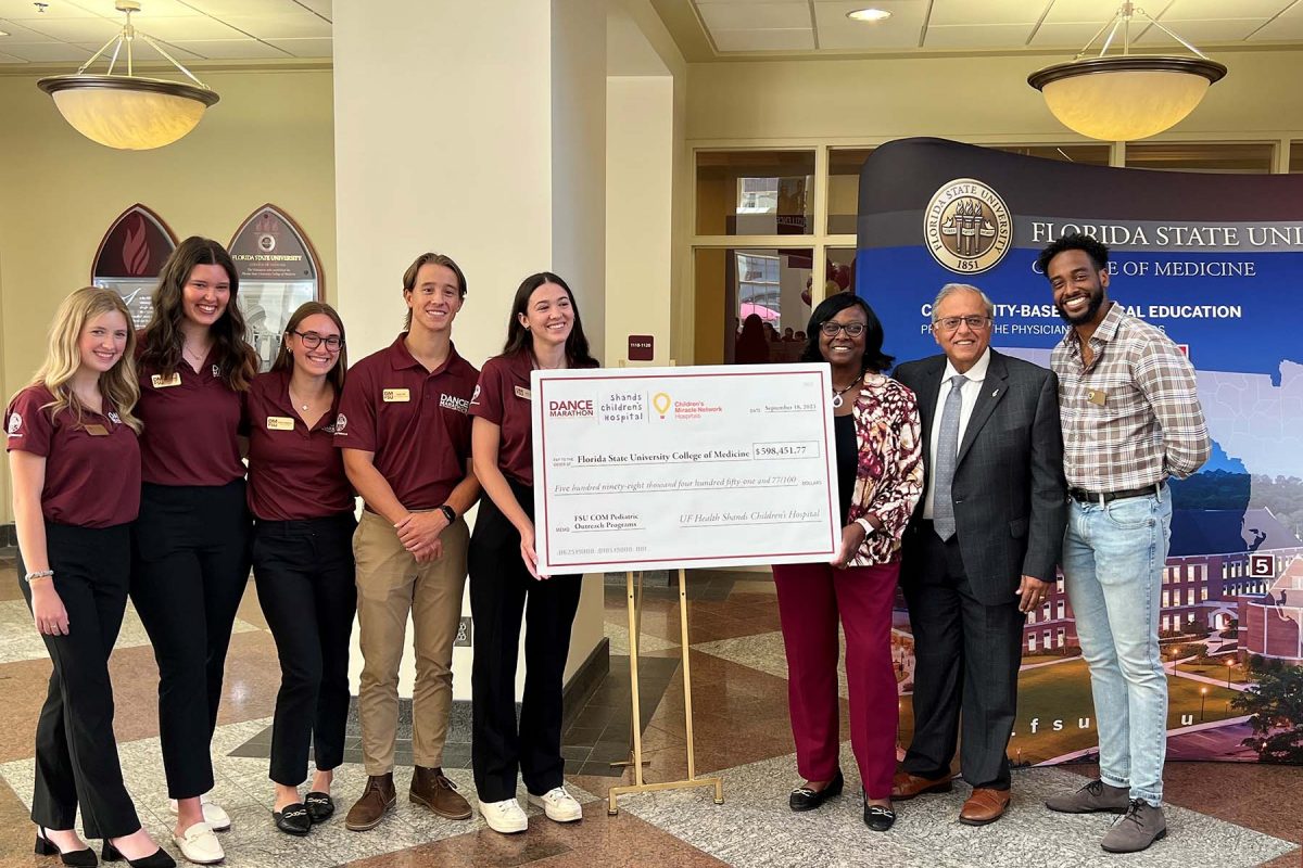 Students from FSU Dance Marathon present a check to FSU College of Medicine Interim Dean Dr. Alma Littles, third from right, and Dr. Rashmin Savani, second from right, chair of the UF College of Medicine Department of Pediatrics and physician-in-chief for UF Health Shands Children's Hospital. Also pictured is second-year FSU medical student David Labissiere, far right, president of the Pediatric Interest Group.