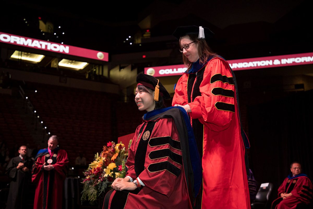 A Florida State University faculty member hoods a doctoral graduate the fall doctoral hooding ceremony Friday, Dec. 15, 2023, at the Donald L. Tucker Civic Center. (FSU Photography Services)