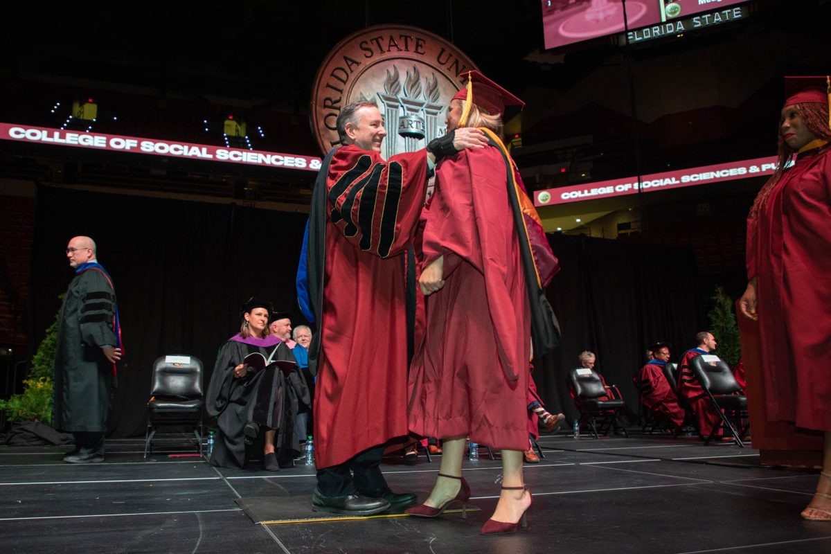 President Richard McCullough congratulates a graduate during commencement Friday, Dec. 15, 2023, at the Donald L. Tucker Civic Center. (FSU Photography Services)