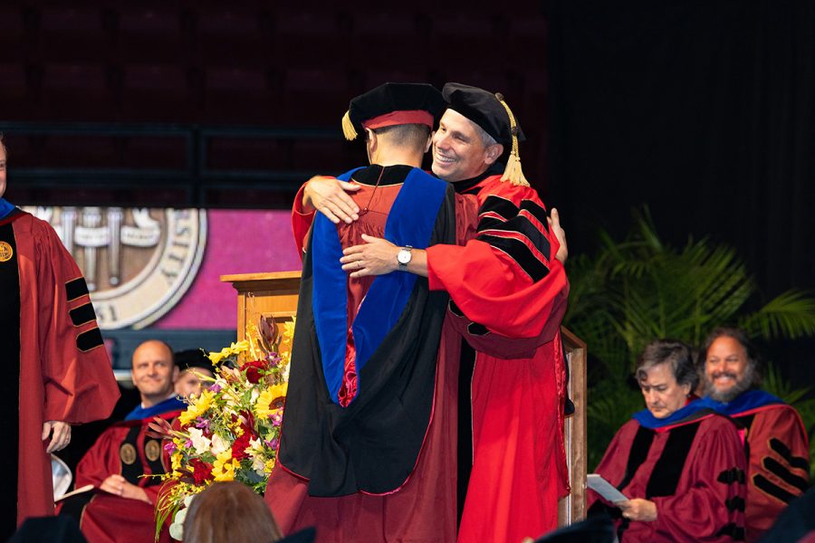 A Florida State University faculty member embraces a graduate during the summer doctoral hooding ceremony, Friday, Aug. 1, 2025, at the Donald L. Tucker Civic Center. (FSU Photography)