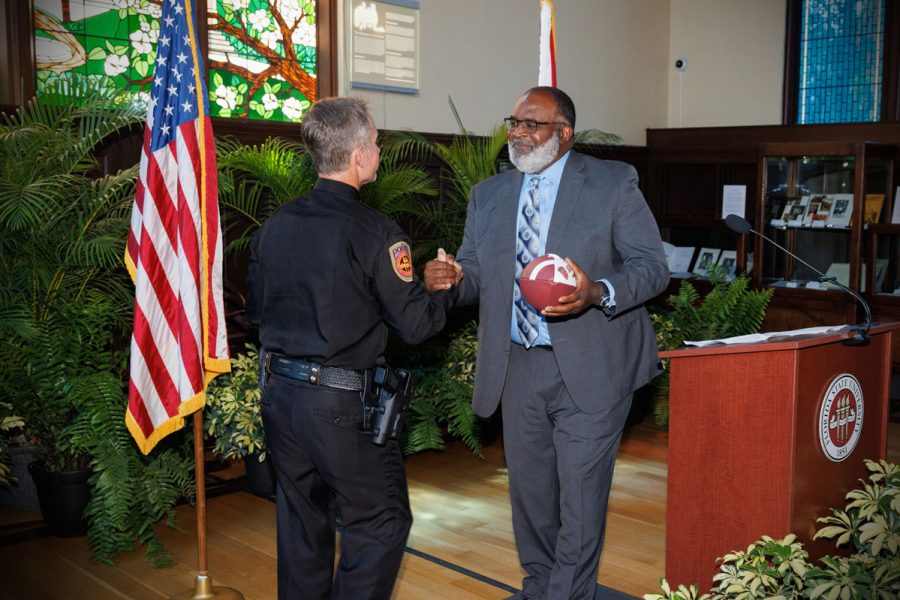 Associate Head Football Coach Odell Haggins gives Chief Trumbower with a football, a nod to his days playing for the Seminoles under Coach Bobby Bowden. (Bill Lax/FSU Photography)
