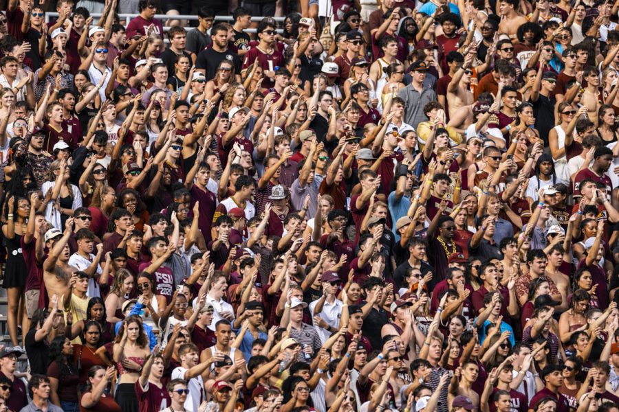 The crowd of a football game does a handful of signal