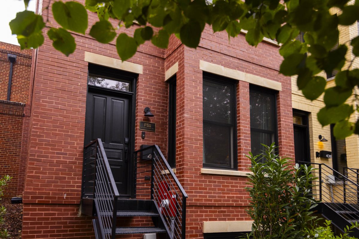 Red brick building with black door and railing