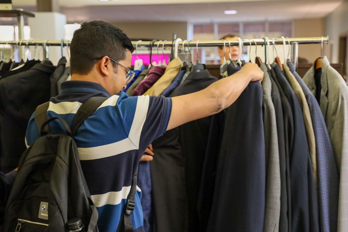 A man looks at suits hung up on a rack
