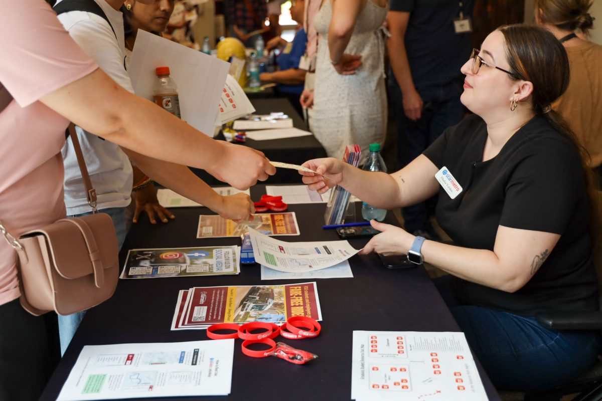 A person hands a student a piece of paper