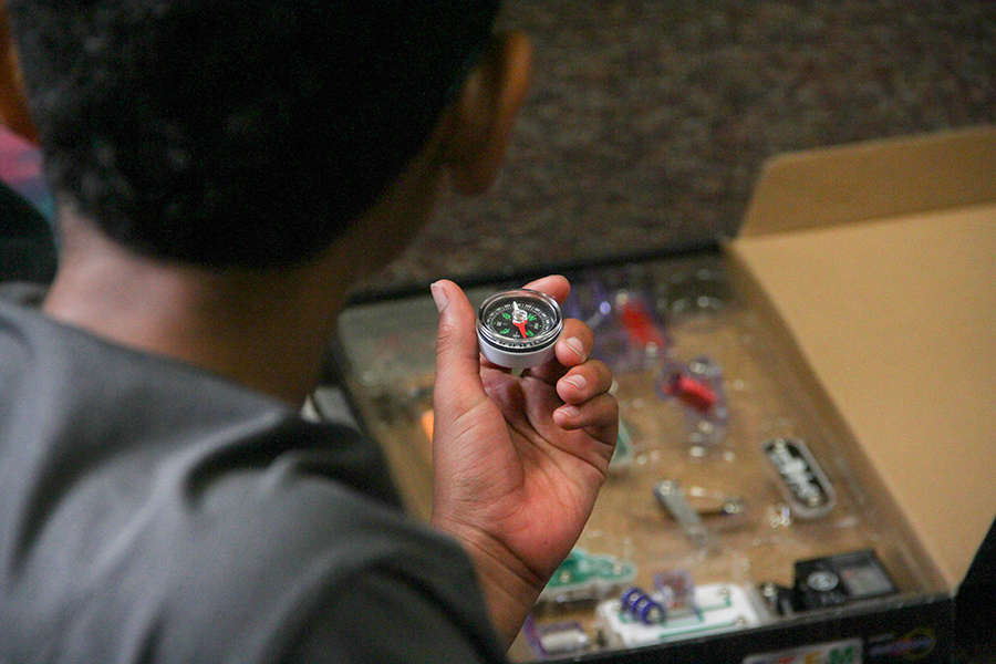 Child holds a compass, in focus
