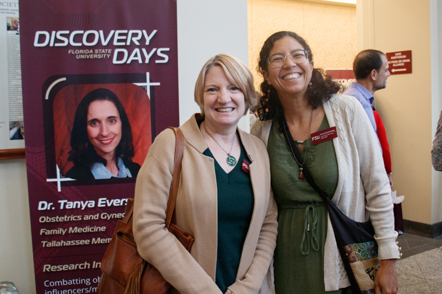 Attendees at Clinical Catalyst with a Discovery Days poster behind them. (Casey McCarthy/University Communications)