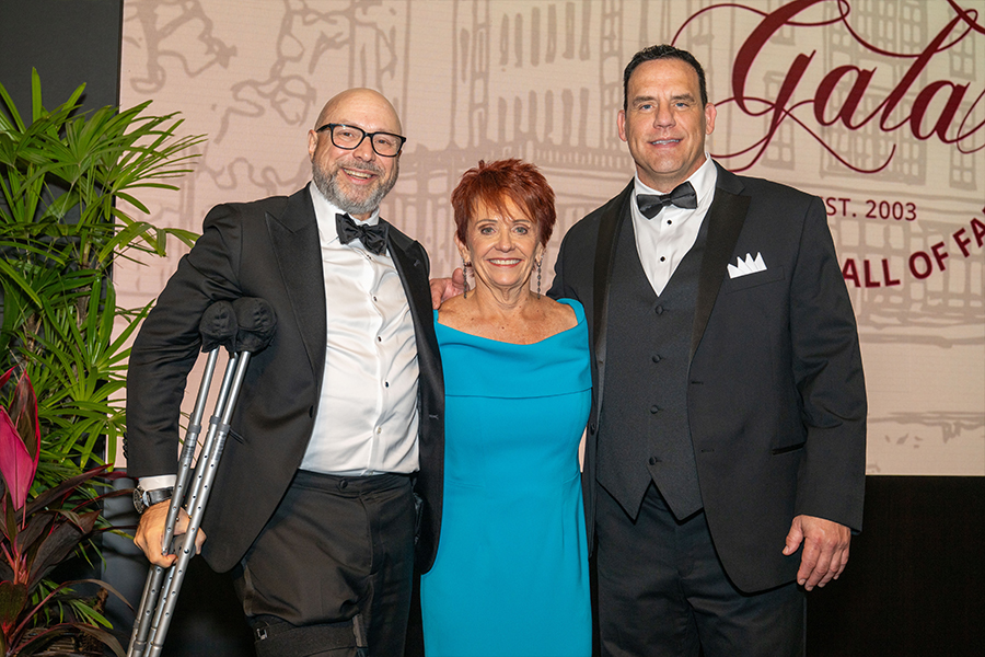 Three people in formal clothing smiling for the camera