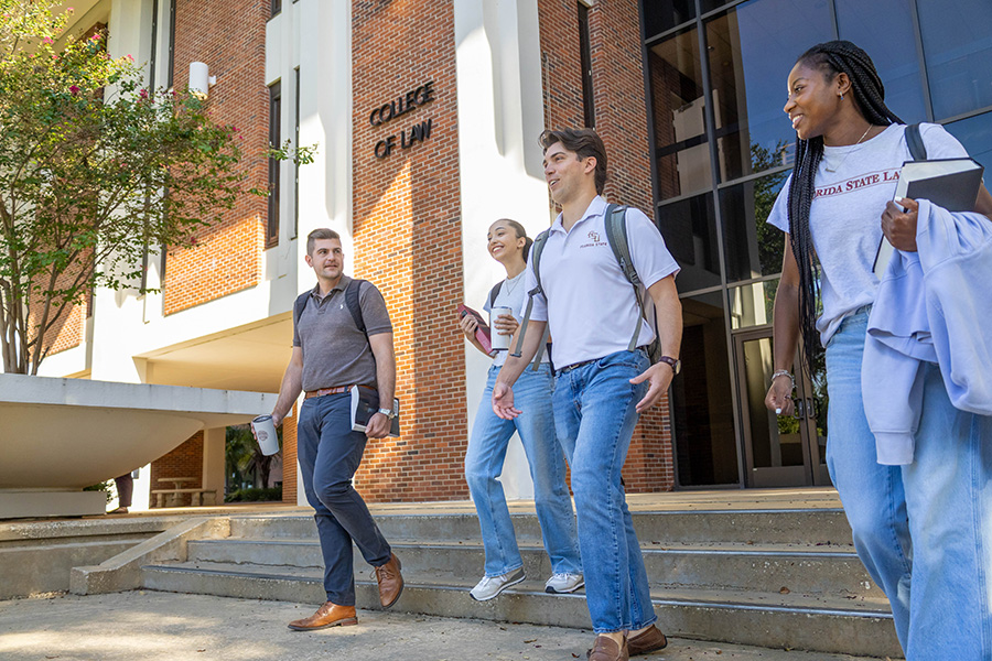 Students walk down stairs, mingling