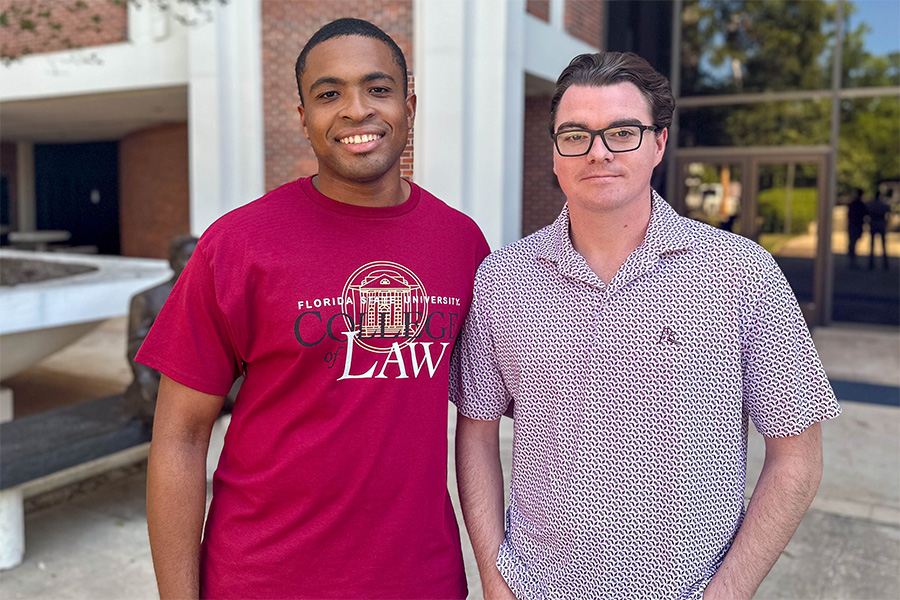 Two students smile for the camera