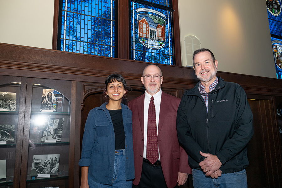 Horizontal image of three people posing for a picture, smiling