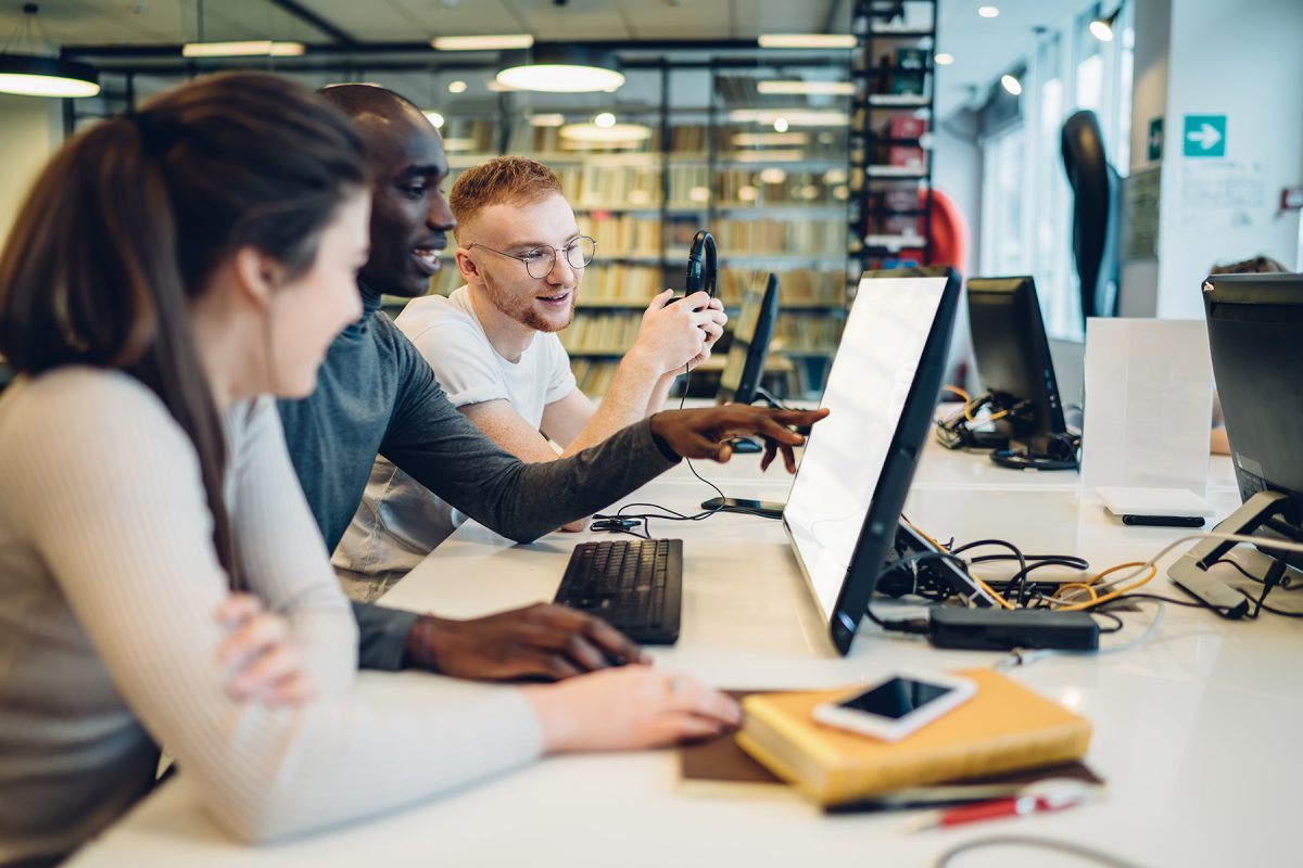 Stock photo of students looking at a computer