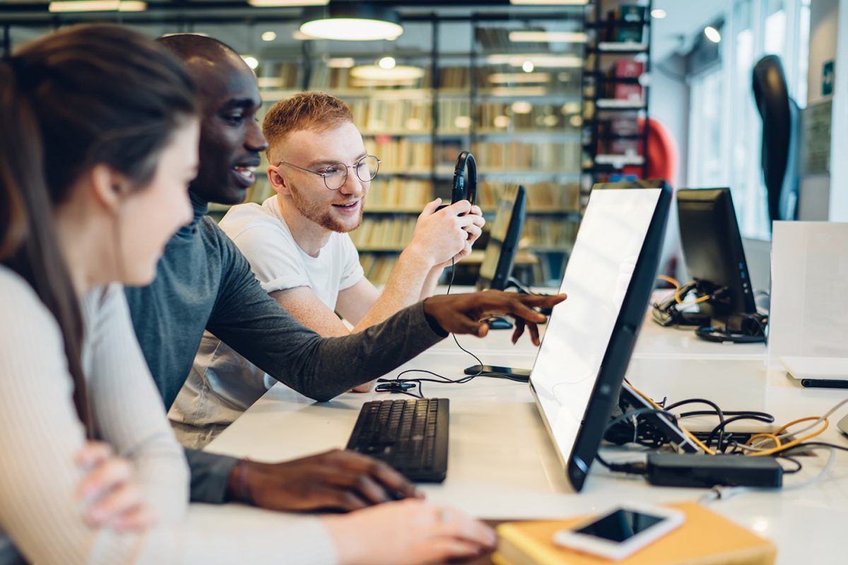 Stock photo of students looking at a computer
